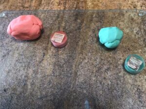 Orange and green gum paste portions prepared for carrot toppers.