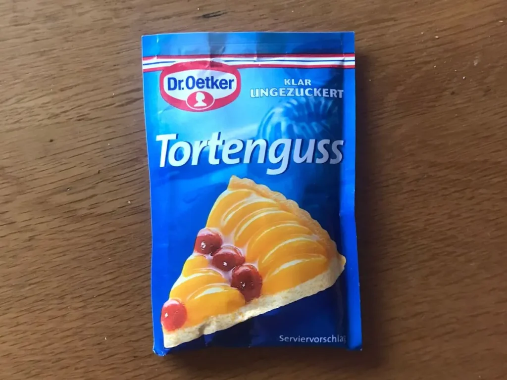 Dr. Oetker clear Tortenguss, featuring an image of a fruit flan with peach slices and cherries.