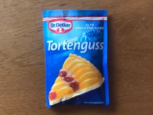 Dr. Oetker clear Tortenguss, featuring an image of a fruit flan with peach slices and cherries.