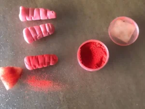 Mini gum paste carrots dusted with orange food colouring powder.