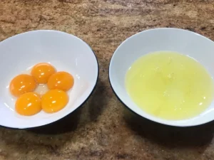 Egg yolks and egg whites separated for cheesecake filling