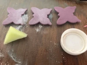 Applying luster dust to gum paste butterflies using a small piece of sponge.