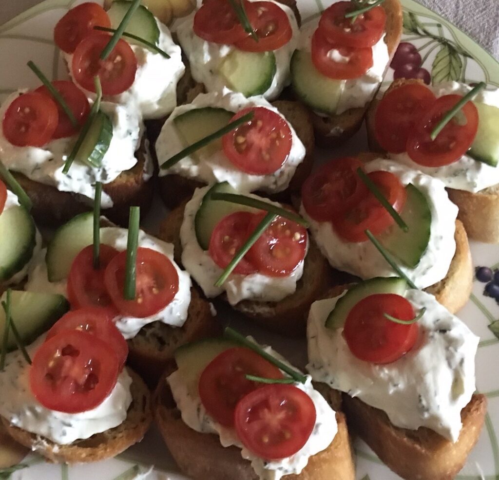 Garlic and Herbs Cottage cheese served on baguette garnished with tomatoes cucumber and chives