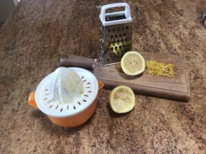 Fresh lemon being zested and juiced on a kitchen counter for Syrupkuchen cookies.