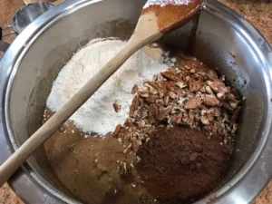 Mixing flour, cocoa and pecans for chocolate brownie batter