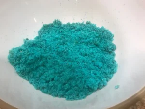 Bright blue cake crumbs in a white mixing bowl, ready to be used in a fun cake pop recipe for kids.