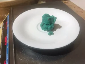 A small piece of blue cake pop mixture being weighed