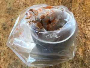 Melted chocolate prepared for drizzling over brownies