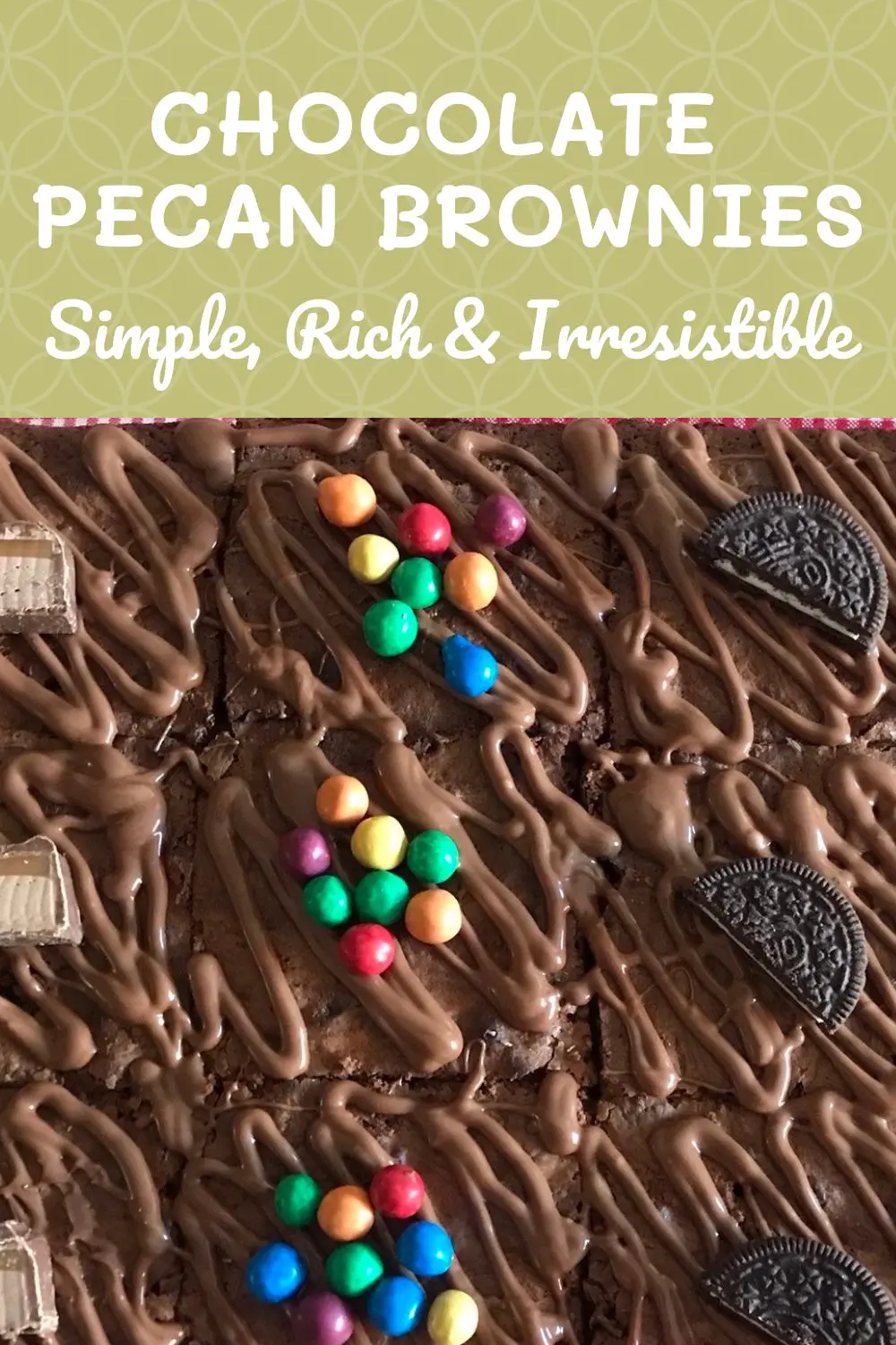Chocolate brownies topped with drizzled chocolate and decorated with mini chocolate bars, colourful candy-coated chocolates, and Oreo halves.