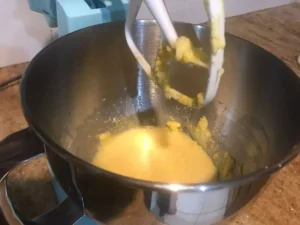 Eggs and rum being mixed into the butter and sugar mixture