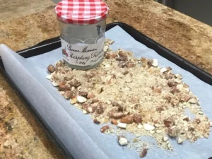 Cooled almond brittle being crushed for Frankfurter Kranz topping