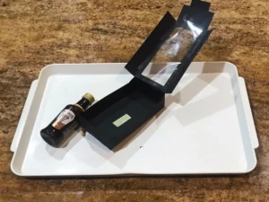 Small bottle secured inside a DIY party favour box with double-sided tape