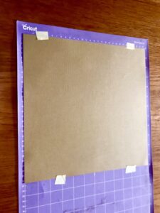 Attach the cardstock to the mat using masking tape