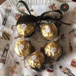 A small Ferrero Rocher wreath tied with a green ribbon.