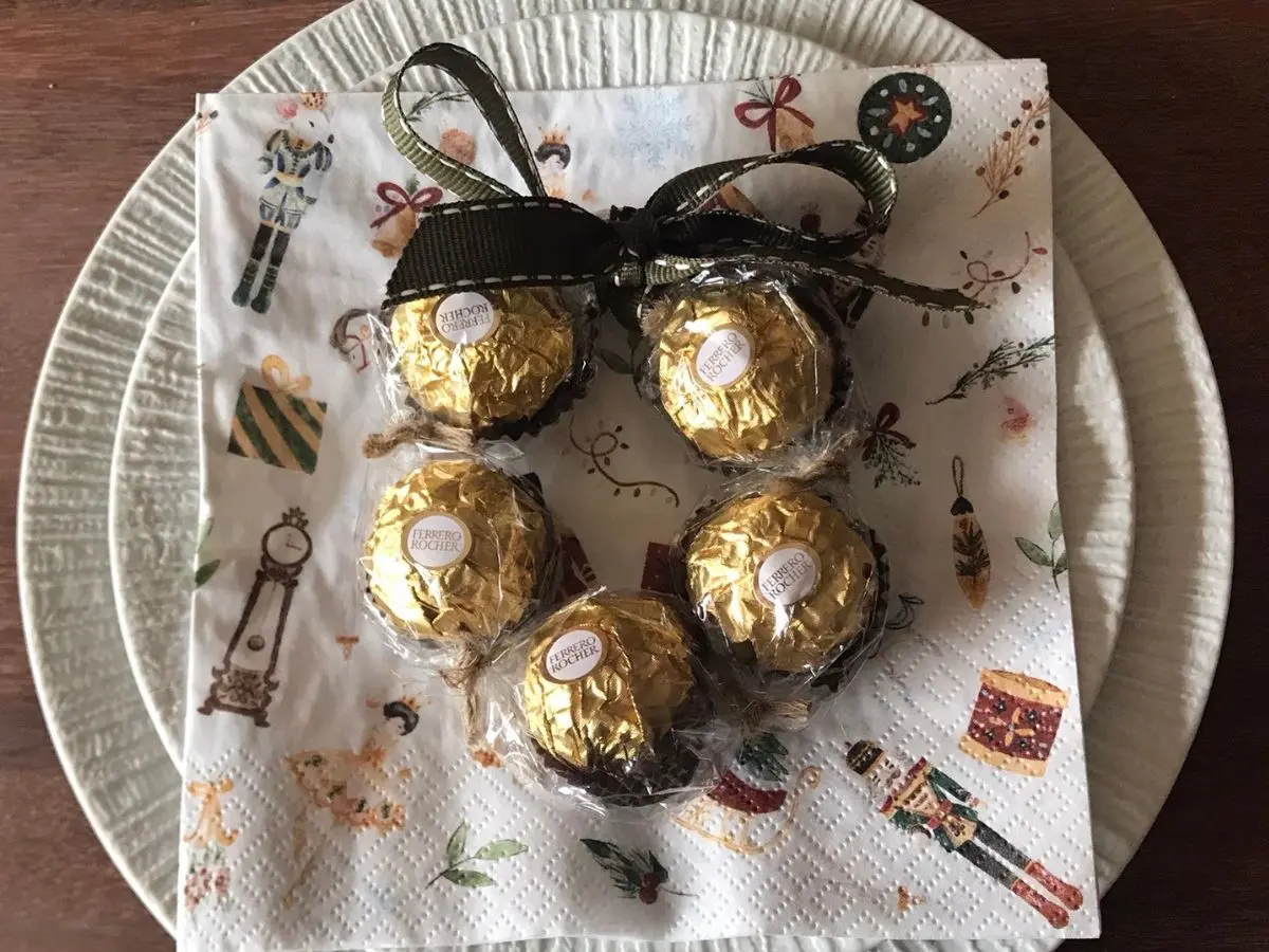 A small Ferrero Rocher wreath tied with a green ribbon.