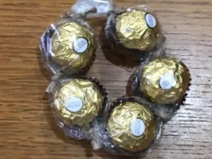 Five Ferrero Rocher chocolates wrapped together with cellophane. and arranged in a circle.