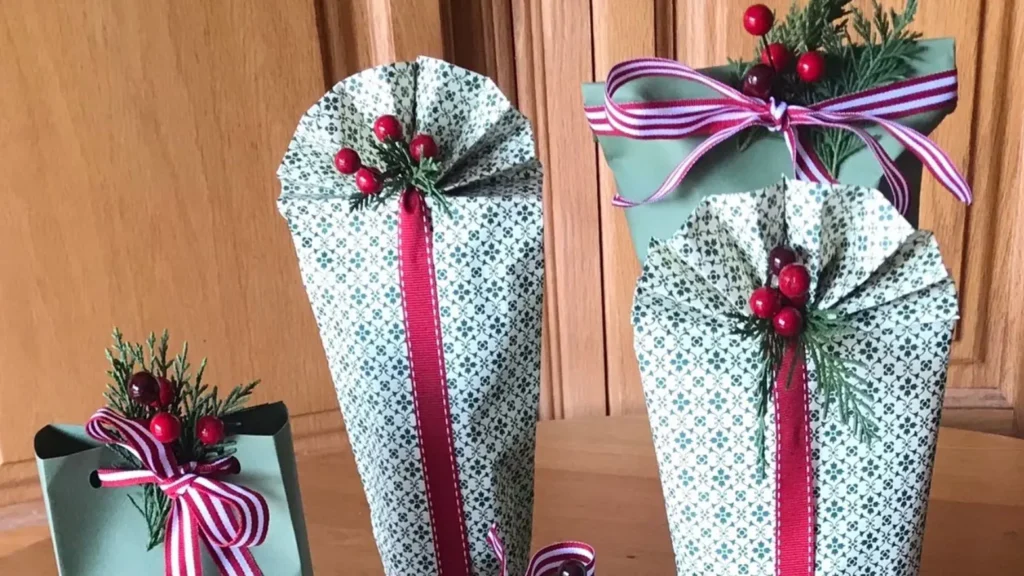 Handcrafted Christmas gift packages decorated with greenery, red berries, and striped ribbon.