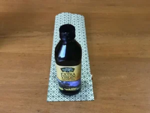 Folding wrapping paper up to create the base of a bottle gift