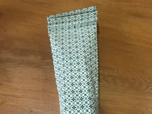 Bottle inserted into gift wrap with accordion folds at the top