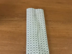 Securing wrapping paper with tape and creasing the sides