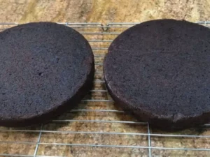 Baked chocolate cake layers cooling on a wire rack