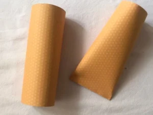Two rolled orange patterned paper sheets