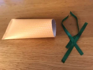 Orange patterned paper roll with green ribbon