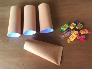 Orange paper rolled into carrot favour with candies nearby
