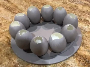 Blown eggshells arranged in a circle on a plate to create a DIY Easter centrepiece base.