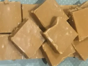 Homemade South African fudge cut into squares, displayed on a polka dot surface, perfect as a sweet party favour.