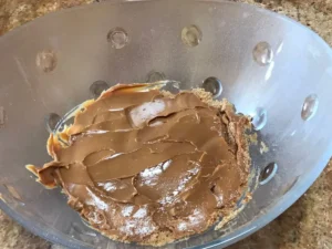 Half the caramel treat spread evenly over the pudding layer in a glass bowl