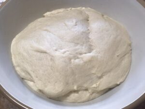 Soft and puffy cinnamon roll dough after rising in a greased bowl.