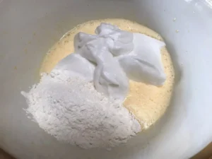 Whipped egg whites and flour mixture added to the yolk mixture for Strawberry and cream Swiss Roll