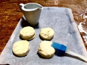 Unbaked butter scones arranged on a lined baking tray