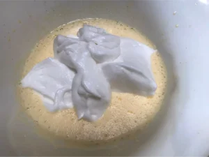 Whipped egg whites added to the yolk mixture for Strawberry and cream Swiss Roll