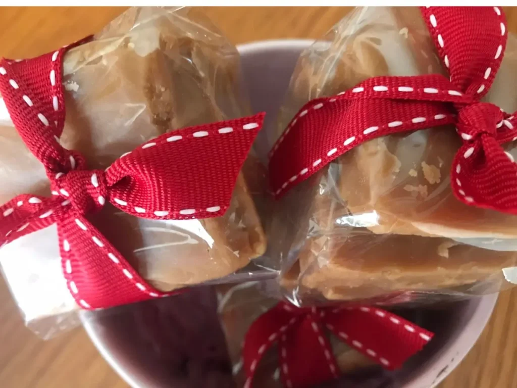 Homemade South African fudge wrapped in clear cellophane and tied with red ribbon, making a sweet Valentine's Day treat or gift.