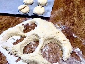 Cutting butter scone dough into rounds on a floured surface