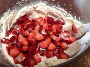 Chopped strawberries and whipped cream for the Swiss roll filling
