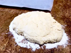 Rolling out butter scone dough on a lightly floured surface