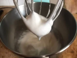 Cream being whipped to soft peaks for the strawberries and cream Swiss roll filling
