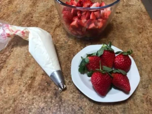 Whipped cream set aside for decorating the strawberries and cream Swiss roll