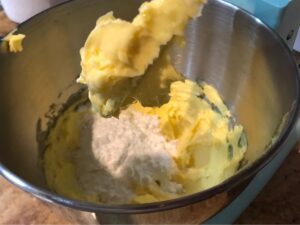 Icing sugar being added to creamed butter and vanilla sugar