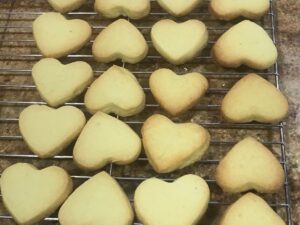 Heart-shaped shortbread cookies arranged on a cooling rack.