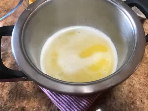 Butter melting in water in a saucepan for choux pastry.