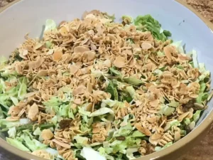 Crunchy cabbage salad for braai topped with toasted slivered almonds and crushed two-minute noodles