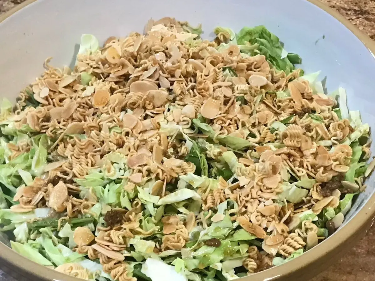 Crunchy cabbage salad for braai topped with toasted slivered almonds and crushed two-minute noodles