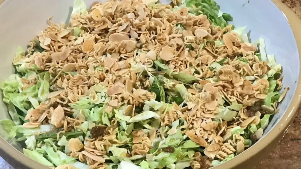 Crunchy cabbage salad for braai topped with toasted slivered almonds and crushed two-minute noodles