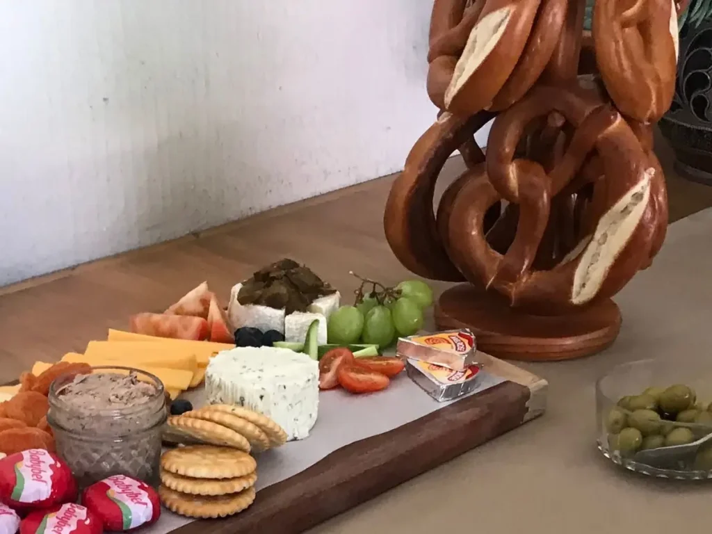 Charcuterie board with cheeses, crackers and pretzels for milestone birthday party