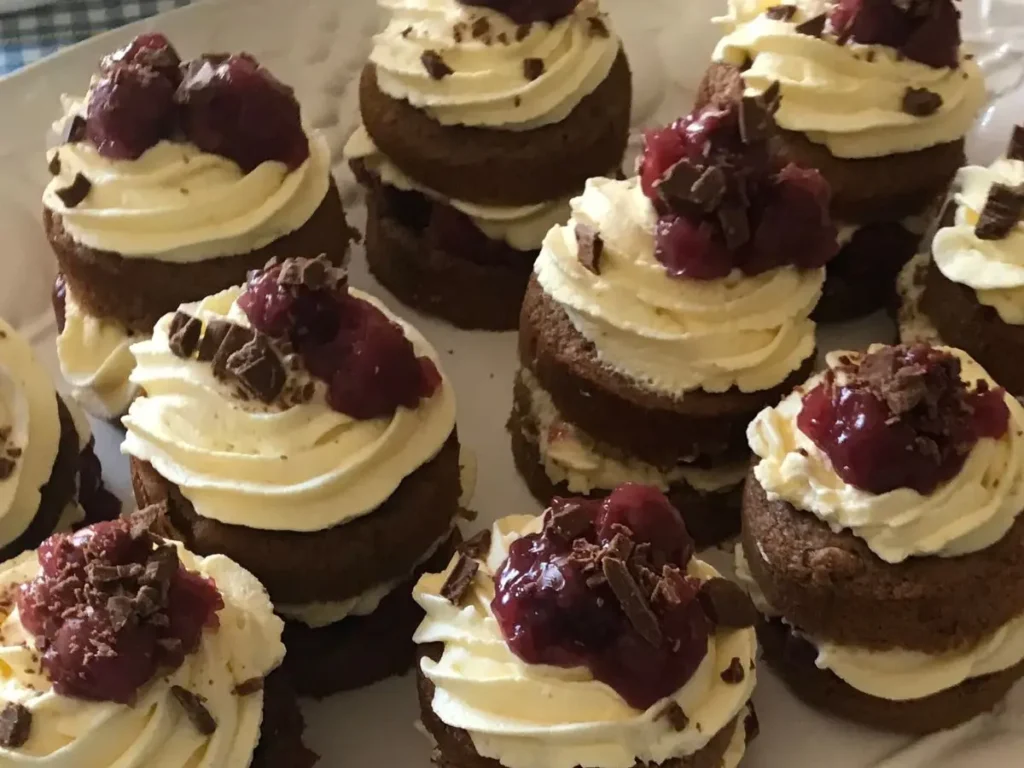 Mini Black Forest cakes with whipped cream, cherries, and chocolate flakes served at a Milestone Birthday Celebration.