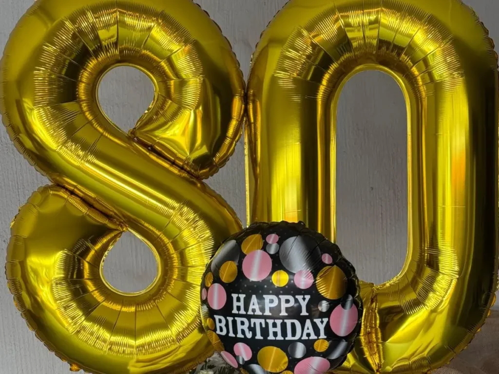 Gold foil number 80 balloons with a black and gold Happy Birthday balloon.